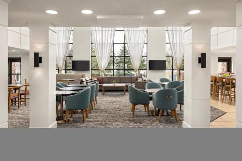 a lobby with chairs and tables and a couch at Staybridge Suites Minneapolis-Bloomington by IHG in Bloomington
