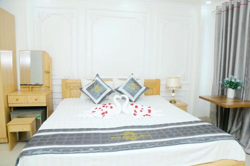 a bedroom with a large white bed with red pillows at Noibai Ville Hotel & Travel in Noi Bai