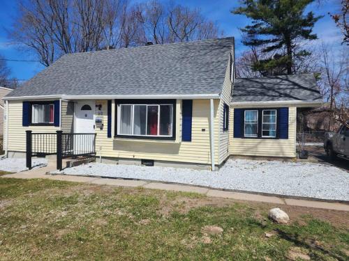 a small yellow house with a roof at Spacious home away from home in Bloomfield