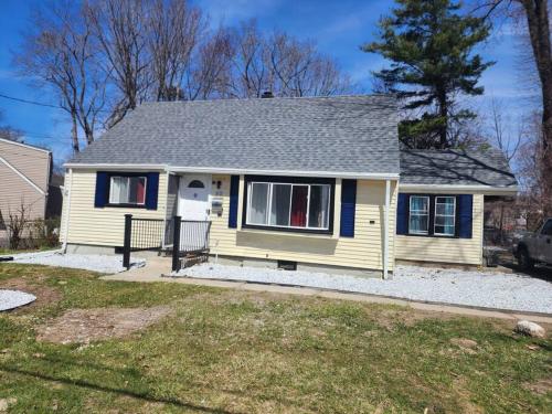 a yellow house with a gray roof at Spacious home away from home in Bloomfield