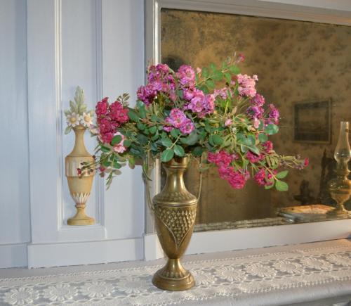 a vase filled with pink flowers on a table at Château de Peufeilhoux in Vallon-en-Sully
