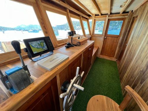 een laptopcomputer op een bureau in een boot bij Leticia Liveaboard in Labuan Bajo