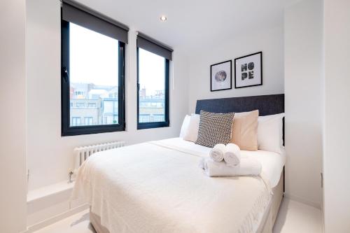 a bedroom with a white bed with two towels on it at Huge & Central 3 Bedr, 4 Beds, Covent Gdn in London