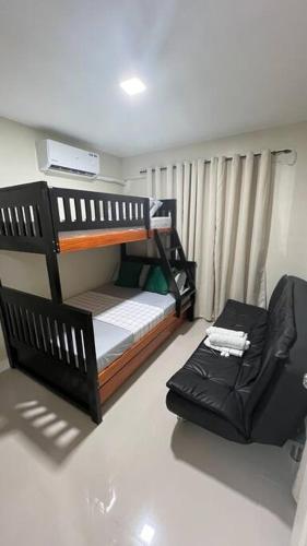 una camera da letto con due letti a castello e una sedia di Charlie's Midori ad Antipolo