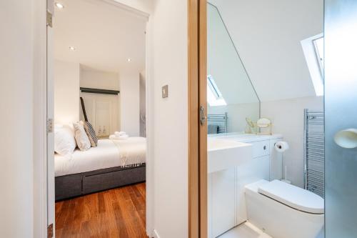 a bathroom with a bed and a sink and a toilet at Huge & Central 3 Bedr, 4 Beds, Covent Gdn in London