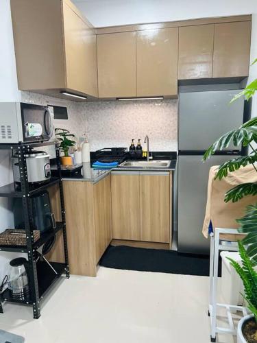 una cucina con mobili in legno e un frigorifero in acciaio inossidabile di Charlie's Midori ad Antipolo