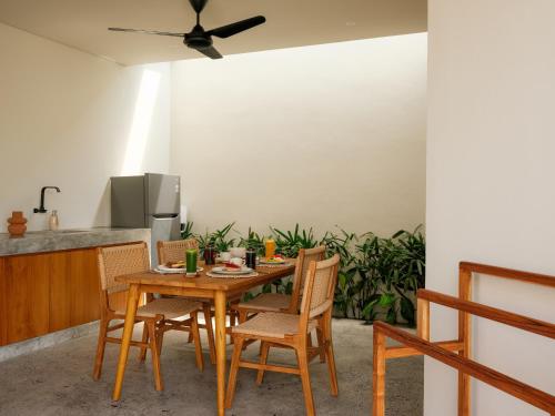 a kitchen with a wooden table and chairs at Suku Lifestyle Hotel & Villas in Selong Belanak