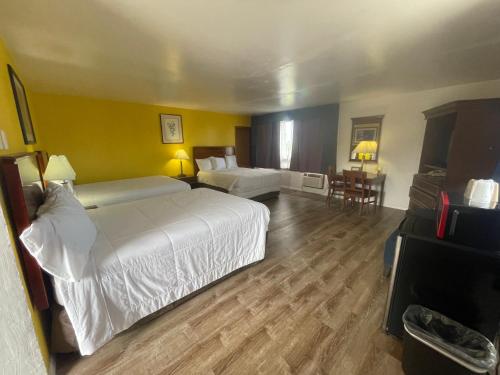 a hotel room with two beds and a television at Motel Oasis in Moses Lake