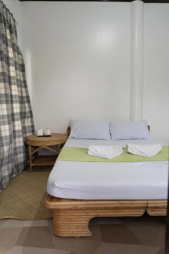 a bedroom with a bed and a table at Shelves Siargao in General Luna