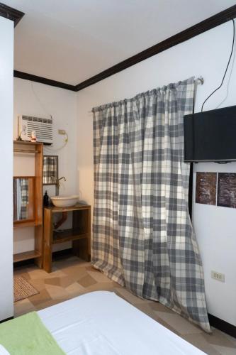 a bedroom with a checkered shower curtain at Shelves Siargao in General Luna