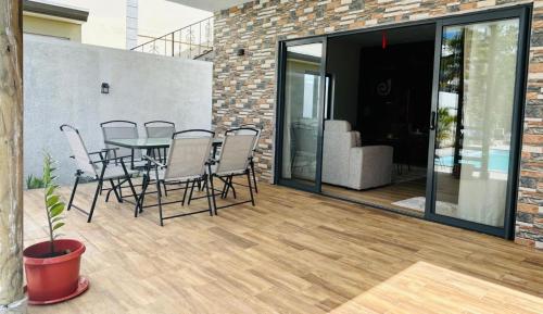 a patio with a table and chairs and a couch at Villa Ellapen in Pereybere