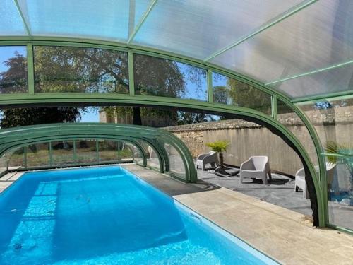 - une piscine dans une maison dotée d'un plafond en verre dans l'établissement Demeure charmante bordant l'Indre avec piscine, vélos, barque, canoé, pédalo et coin pêche. - FR-1-591-153, à Ardentes