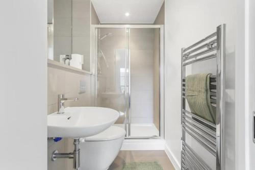 a bathroom with a sink and a toilet and a shower at Centrally Located - Modern - 2Bed - 2Bath Apartment in London