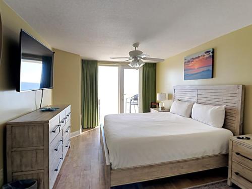 Un dormitorio con una cama grande y un televisor. en Sea Dunes #401, en Fort Walton Beach