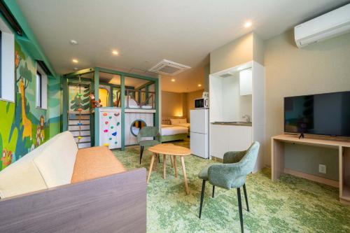 a living room with a couch and chairs and a television at PLAY!! Resi Stay in Kyoto