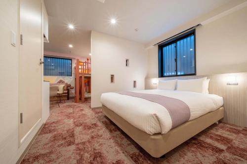 a bedroom with a large bed and a window at PLAY!! Resi Stay in Kyoto