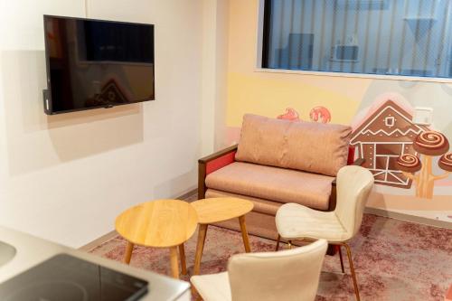 a living room with a chair and a tv at PLAY!! Resi Stay in Kyoto