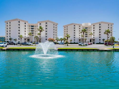 a fountain in the middle of a pond in front of buildings at Regency Towers #802 East in Pensacola Beach