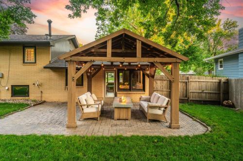 a wooden pergola with two chairs and a table at Brick House in Sioux Falls