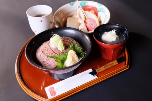 two bowls of food on a tray with chopsticks at ひがし茶屋街らしく金沢 Hotel Rashiku kanazawa in Kanazawa
