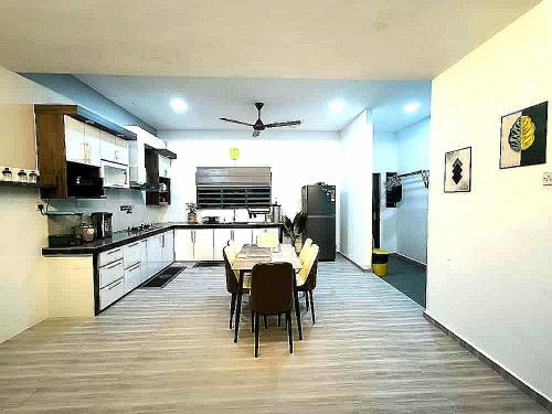 a kitchen with a table and chairs in a room at Homestay Last World Tambun in Kampong Batu Lapan