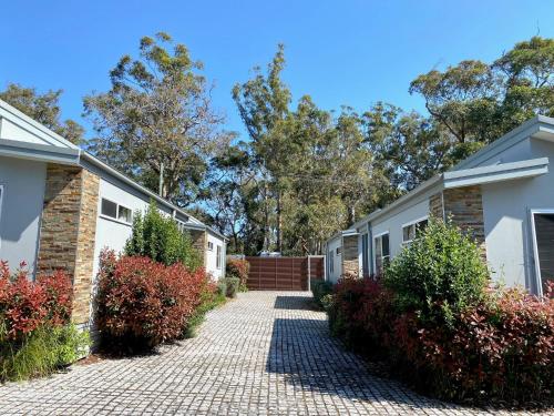 a brick walkway between two white houses at Jervis Bay Mariners in Huskisson