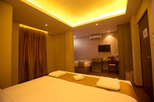 a bedroom with a bed and a desk with a television at Divya Boutique Inn in Kathmandu
