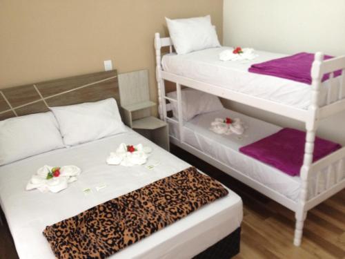 a room with two bunk beds with purple and white towels at Pousada Suite Master Bella Mar in Penha