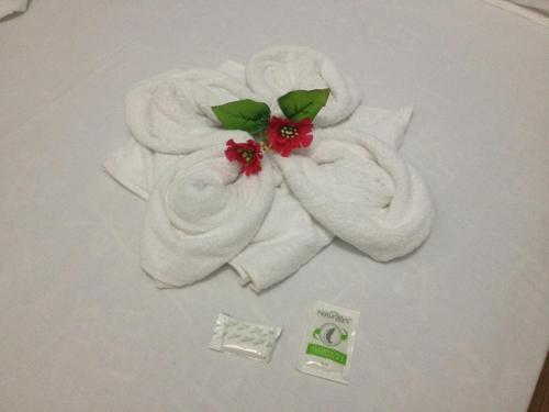 a pile of towels sitting on top of a bed at Pousada Suite Master Bella Mar in Penha