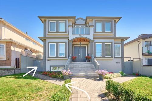 a large house with a staircase in the front yard at Basement Suite In Vancouver in Vancouver
