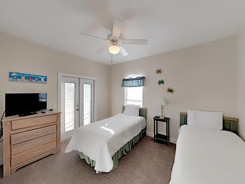 a bedroom with two beds and a flat screen tv at Changes In Latitude in Destin