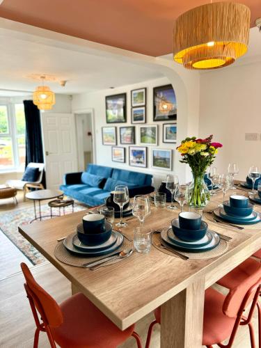 a dining table with chairs and a blue couch at Spacious Home, Walk to City Centre & Free Parking in Worcester