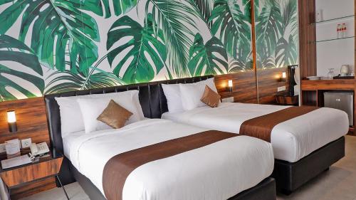 2 letti in una camera d'albergo con murale di Front One Resort Magelang a Magelang