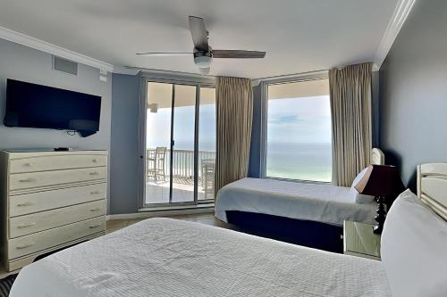 Un dormitorio con dos camas y una gran ventana. en Silver Shells, en Destin