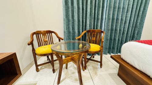 two chairs and a glass table in a bedroom at Atalchhatra Luxury Boutique Hotel in Jaipur