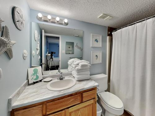a bathroom with a sink and a toilet and a mirror at Phoenix III #3146 in Orange Beach