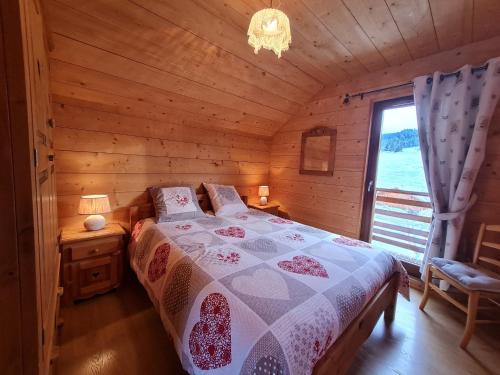 a bedroom with a bed in a log cabin at Chalet chaleureux face aux pistes, proche Gérardmer, idéal pour famille, balcon et terrasse - FR-1-589-182 in Ban-sur-Meurthe-Clefcy