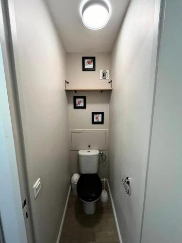 une petite salle de bains avec toilettes et 3 photos sur le mur dans l'établissement Résidence Plagne Lauze - maeva Home - Appartement 2 Pièces 5 Personnes - Prestige MAE-4334, à Mâcot La Plagne