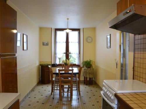 a kitchen with a table and chairs and a window at Gîte de Charme à la Campagne avec Jardin Clos et Collection d'Outils Agricoles - FR-1-581-9 in Vaupillon