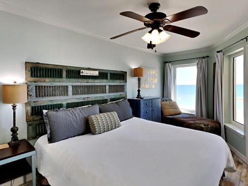 a bedroom with a white bed and a ceiling fan at Boardwalk #787 in Gulf Shores