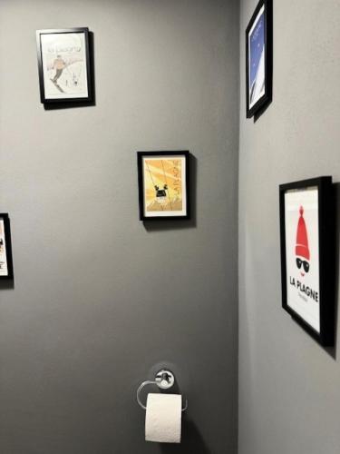un mur avec des photos encadrées et un distributeur de papier toilette dans l'établissement Résidence Plagne Lauze - maeva Home - Studio 4 Personnes - Prestige MAE-2634, à Mâcot La Plagne