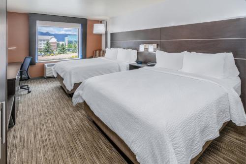 two beds in a hotel room with a window at Holiday Inn Express & Suites - Colorado Springs AFA Northgate by IHG in Colorado Springs