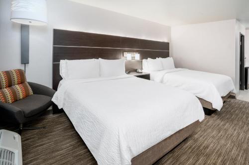 a hotel room with two beds and a chair at Holiday Inn Express & Suites - Colorado Springs AFA Northgate by IHG in Colorado Springs