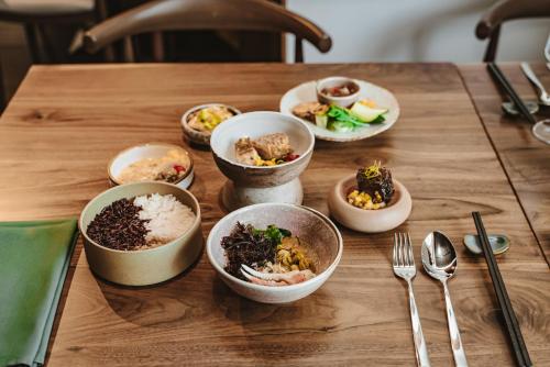 a wooden table with bowls of food on it at Kimpton Hotel Enso by IHG in San Francisco