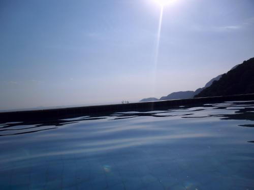 a body of water with the sun in the background at Vila Lia in São Sebastião