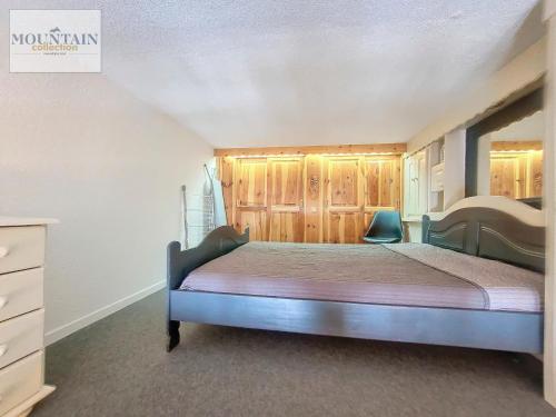 - une chambre avec un lit et des placards en bois dans l'établissement Studio rénové près des pistes avec balcon et parking - FR-1-275-161, à La Rosière