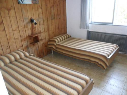 a room with two beds and a window at Hotel Panoramico Bariloche in San Carlos de Bariloche