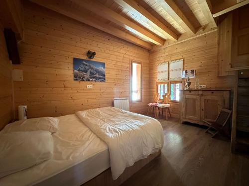 une chambre avec un lit dans une pièce en bois dans l'établissement Appartement rénové au cœur de Morillon, 3 chambres, 8 pers, proche Grand Massif et Lac Bleu, Wi-Fi - FR-1-642-76, à Morillon