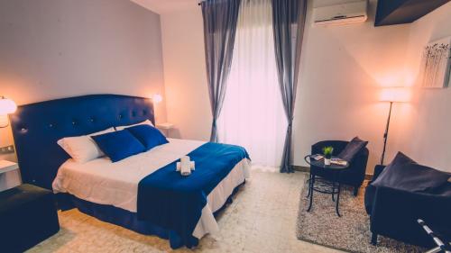 1 dormitorio con 1 cama azul y 1 silla en B&B Civico 46, en Reggio Calabria