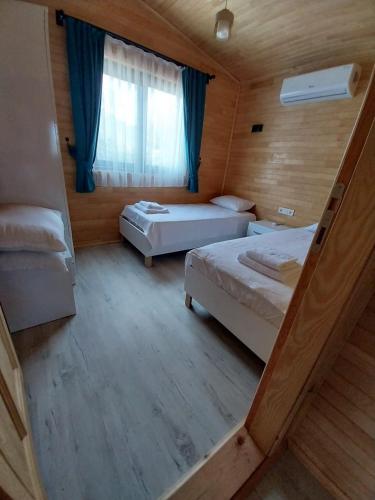 a small room with two beds and a window at Cirali Zambak Villa in Cıralı